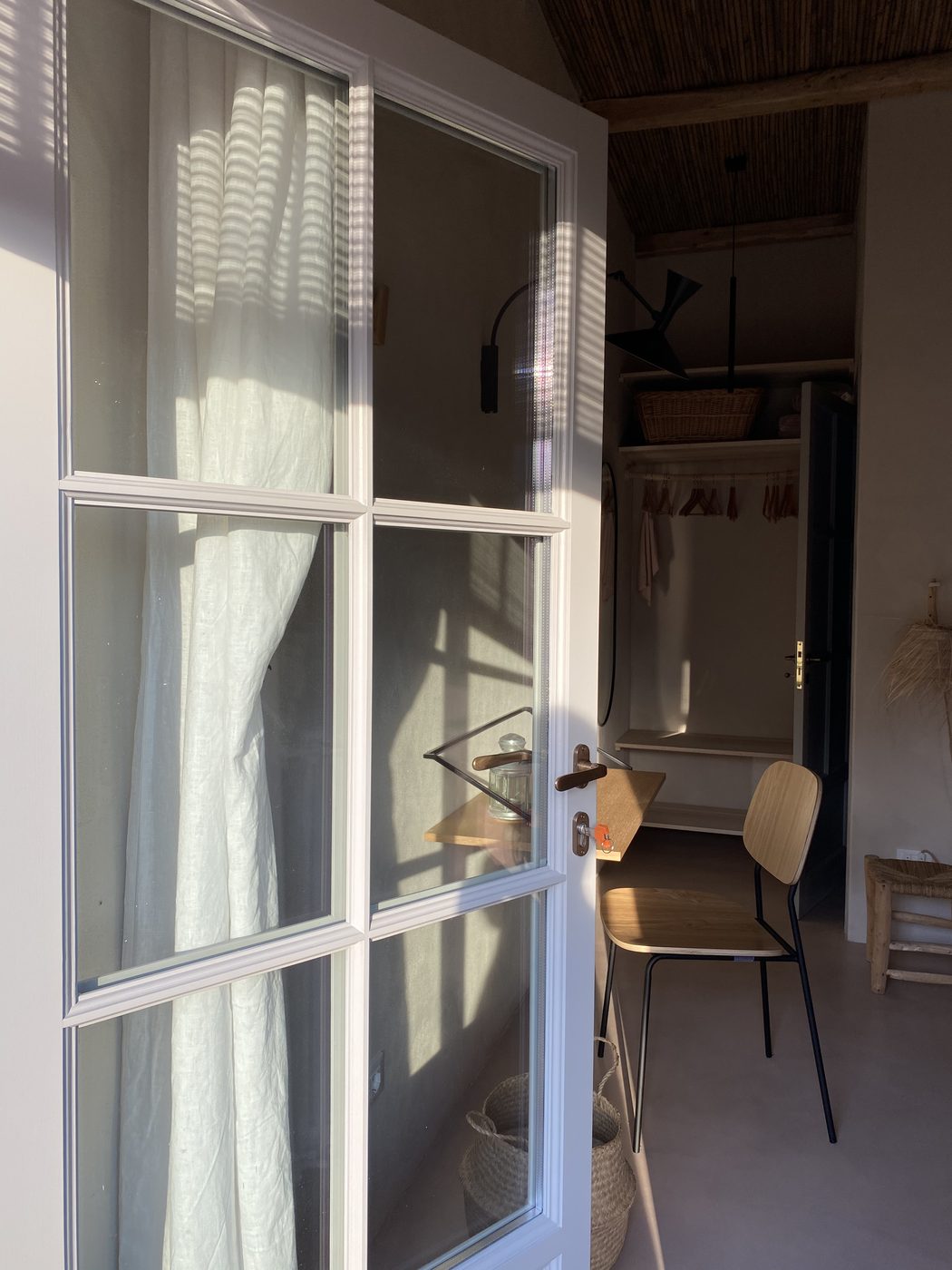 Bedroom doorway at Ca' Remurin, Verezzi, with morning light through linen curtains