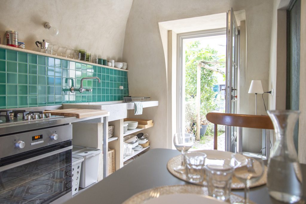 Dining table at Ca' Remurin with the kitchen door open to the private garden, Verezzi, Liguria
